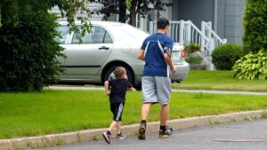 Man and boy in active wear jogging on a street